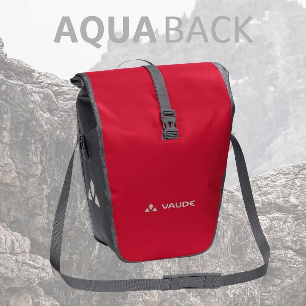 Czerwona torba rowerowa Vaude z szarym paskiem na skalistym tle.