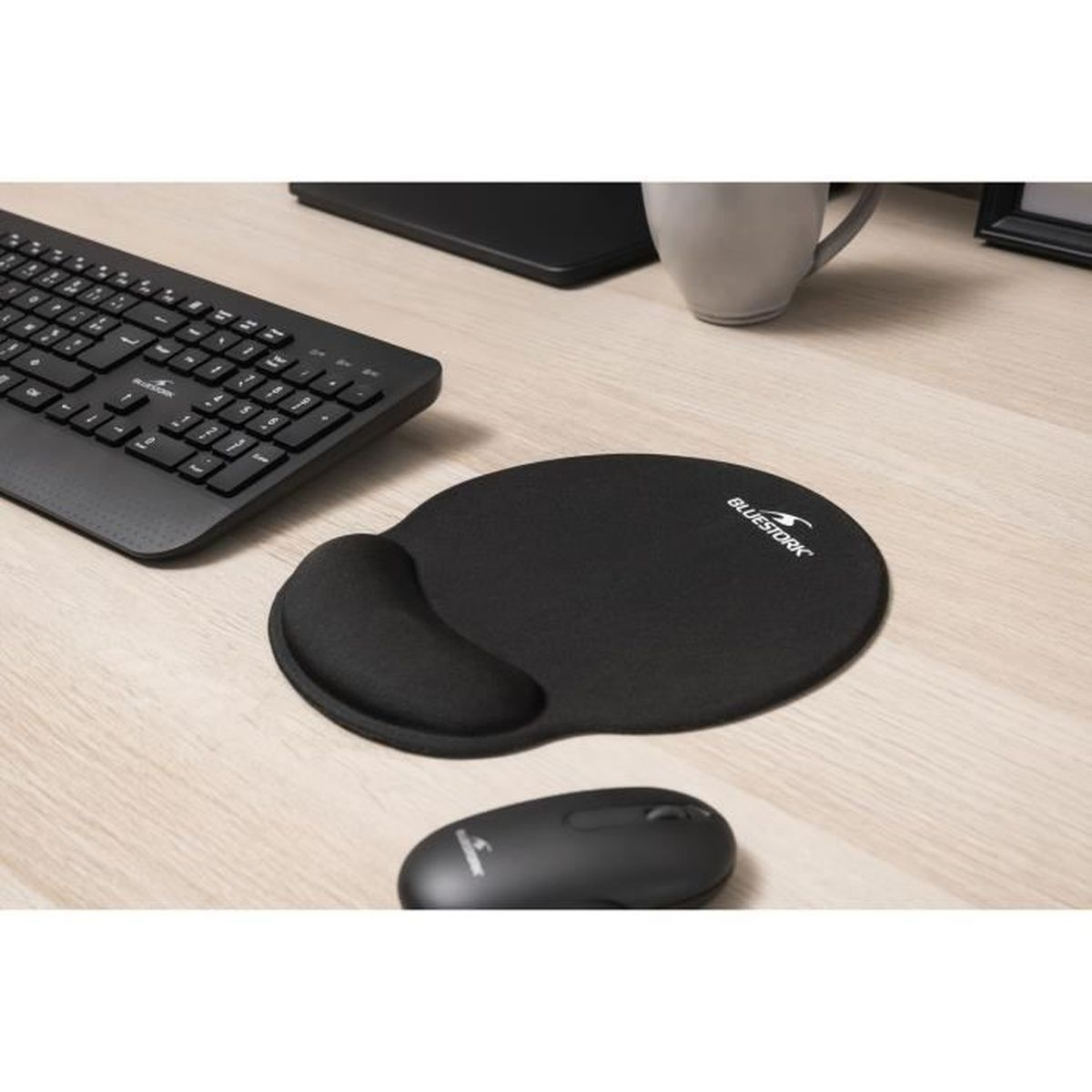 Schwarze Tastatur, Mauspad mit Handgelenkstütze und Maus auf einem Holztisch.