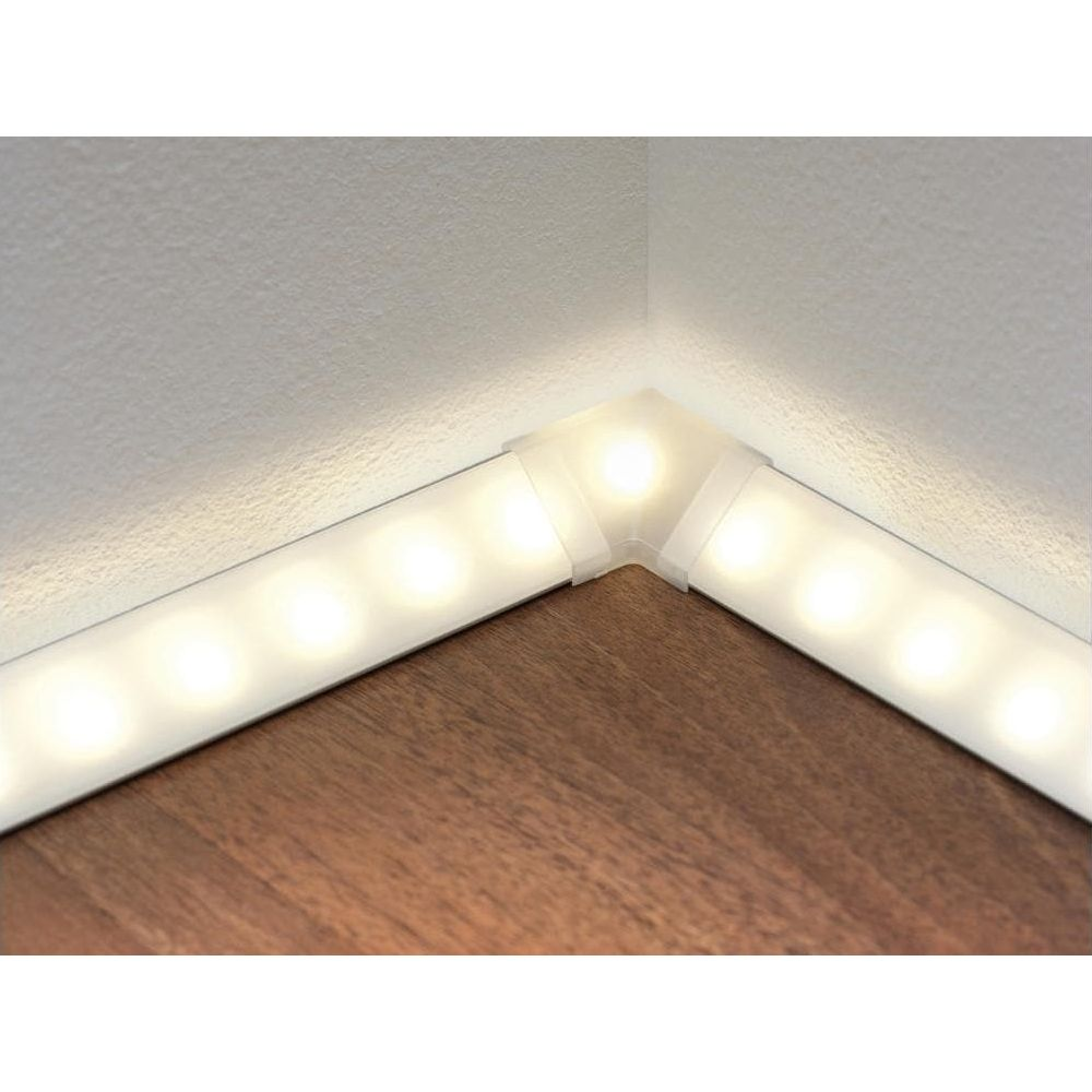 Eine LED-Leiste beleuchtet eine Ecke zwischen Wand und Holzboden.