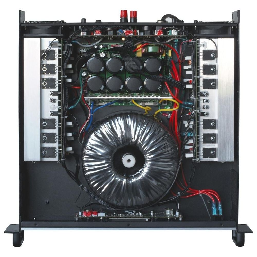 Vista interior de un amplificador con un gran transformador toroidal y muchos condensadores.