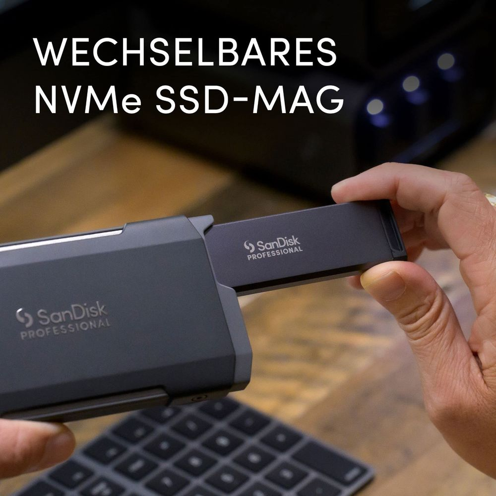 Dłoń wkłada ciemny dysk SanDisk SSD do obudowy. Tekst: Wechselbares NVMe SSD-Mag.