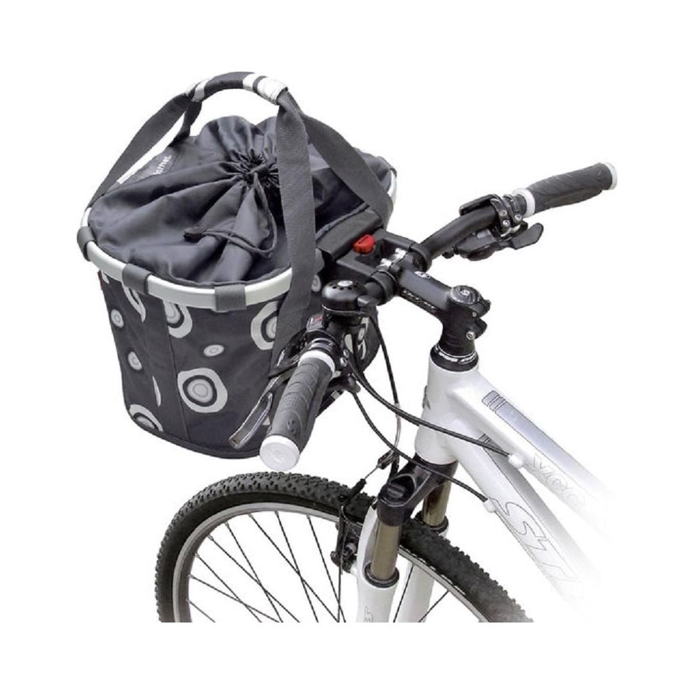 Kierownica roweru z doczepionym czarnym koszem. Kosz ma wzór białych kół.