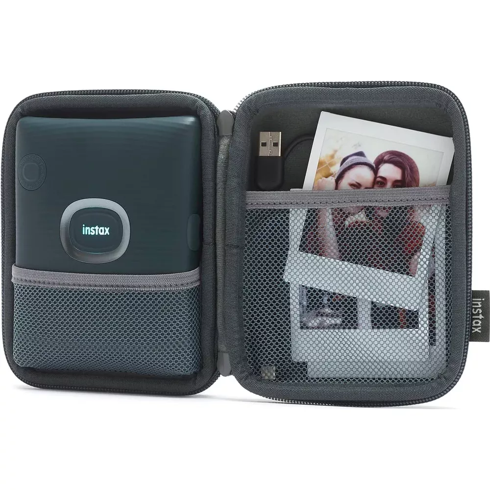 Ein offenes graues Etui mit einem dunklen Drucker, USB-Kabel und Fotos.