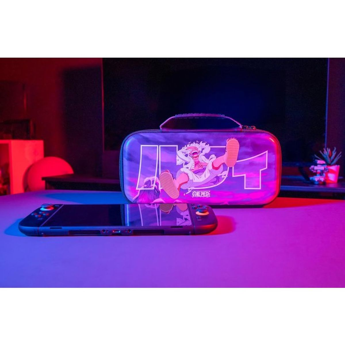 Ein Nintendo Switch und eine lila Tasche mit One Piece-Motiv stehen nebeneinander.