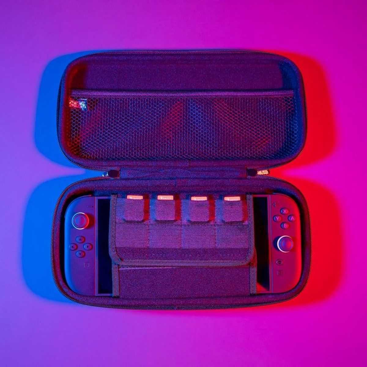 Ein offenes Nintendo Switch Etui mit einer Konsole und Speicherkarten.