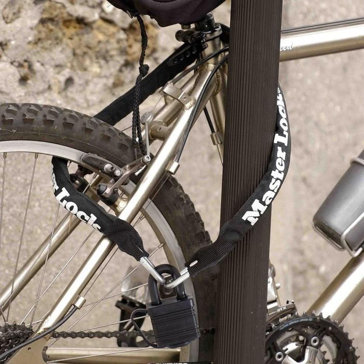 Lucchetto Master Lock a catena assicura un telaio di bicicletta a un palo.