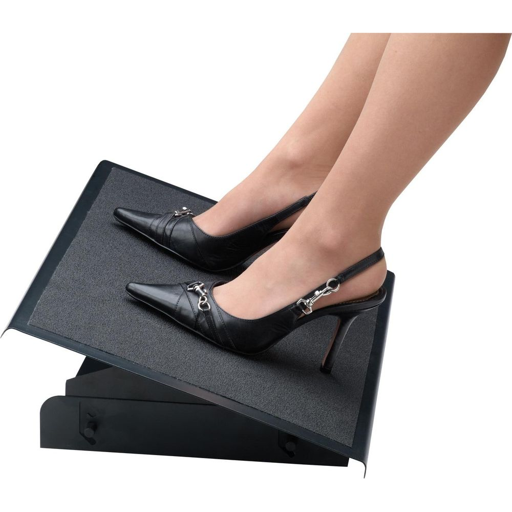 Black slingback heels with metal buckles on a black footrest.