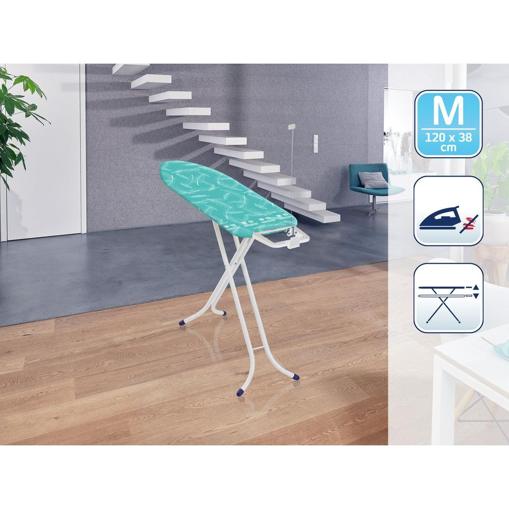 Deska do prasowania z turkusową okładką stoi na drewnianej podłodze.