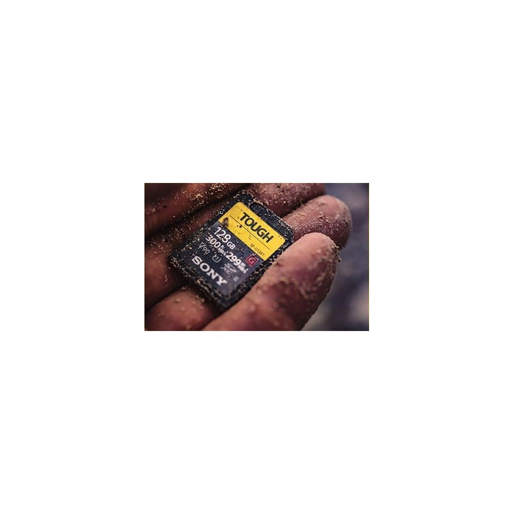 Eine Hand hält eine Sony TOUGH 128GB SD-Karte mit Schmutz.