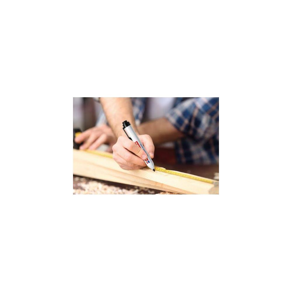 Ein Mann markiert mit einem Stift Holz mit einem Maßband.