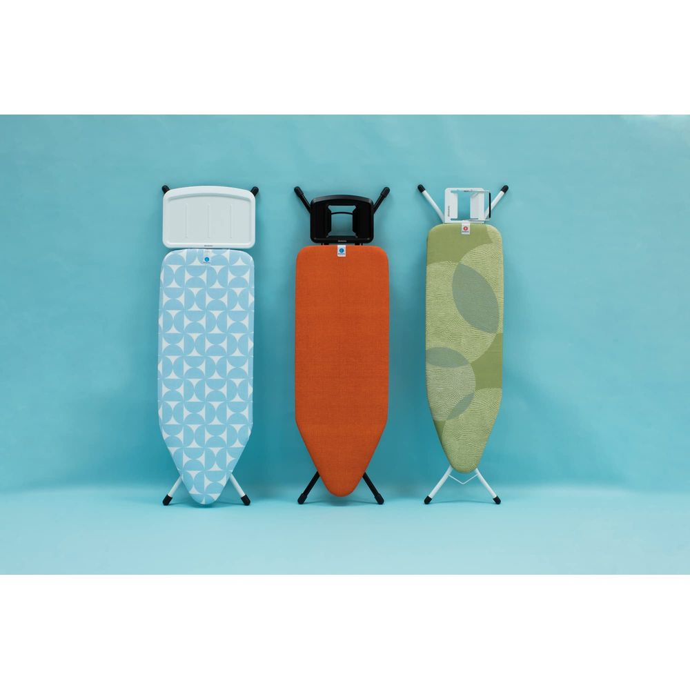 Trois tables à repasser avec motifs bleu, orange et vert sur fond bleu.
