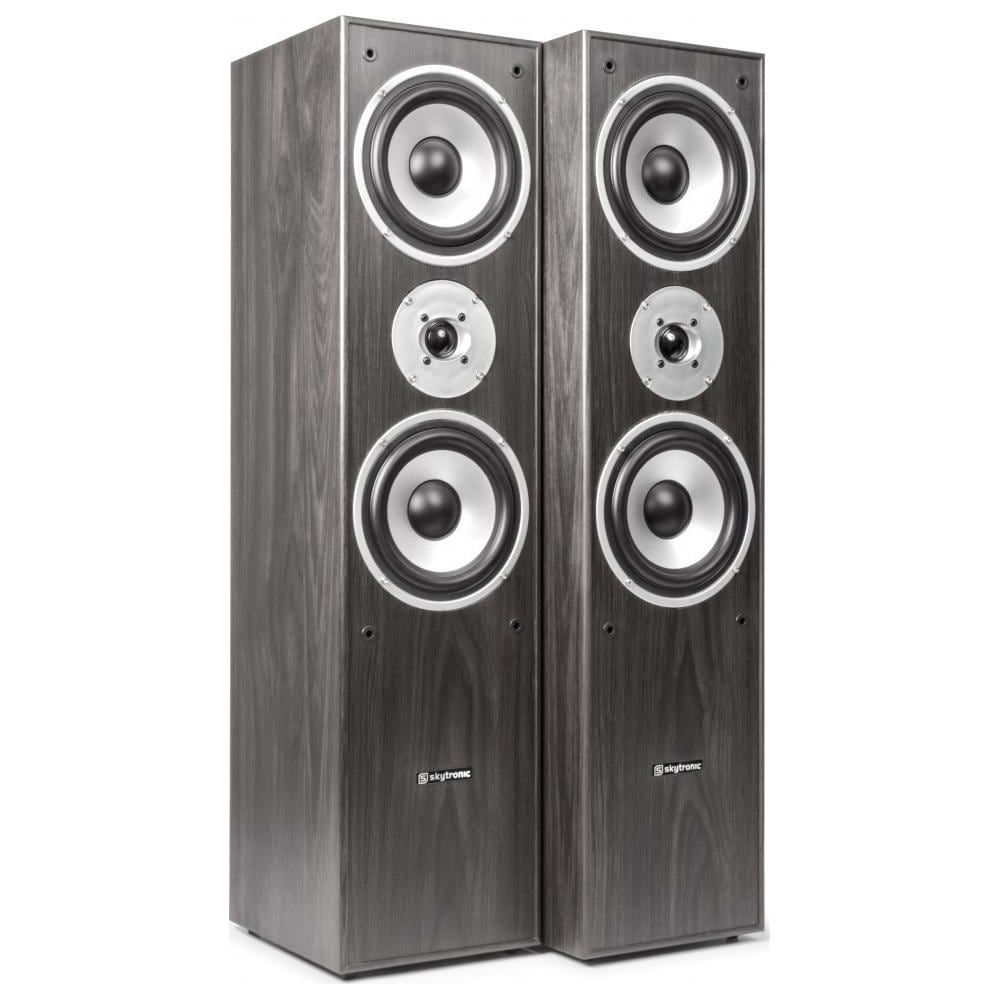 Dos altavoces altos de madera oscura con conos plateados, uno al lado del otro.