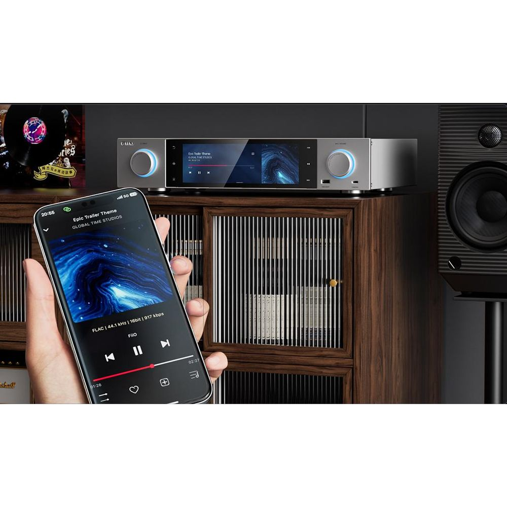 Un teléfono muestra reproducción de música junto a un equipo de música y un altavoz.
