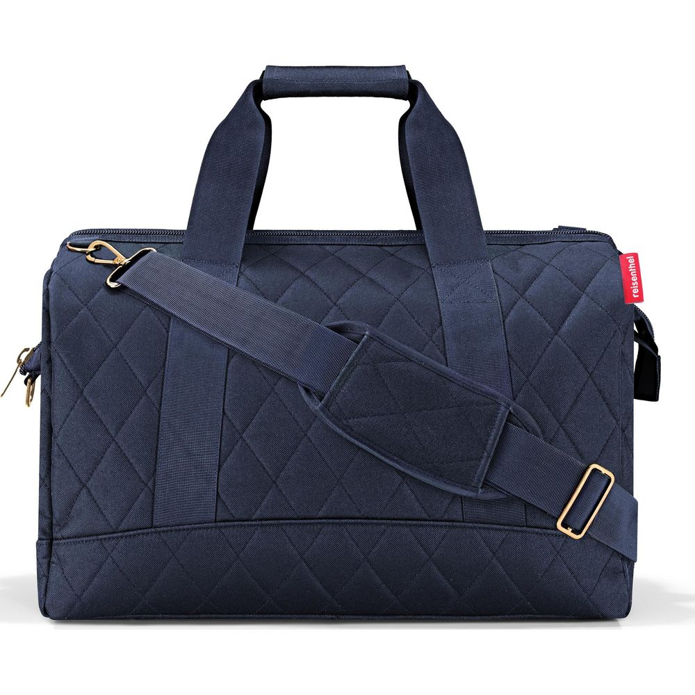Un bolso de viaje acolchado, azul oscuro, con asas y correa.
