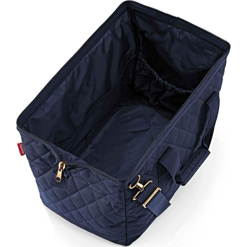 Una bolsa de lona acolchada azul marino, abierta mostrando su interior espacioso con bolsillos.