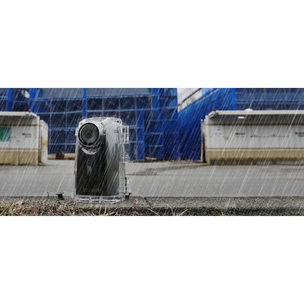 Una fotocamera impermeabile è sotto la pioggia di fronte a edifici in costruzione.