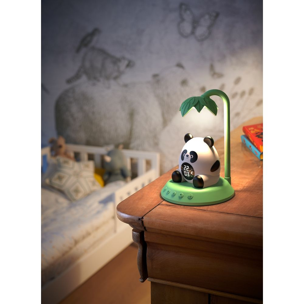 Una lampada panda con paralume a foglia su un comodino accanto a un letto.