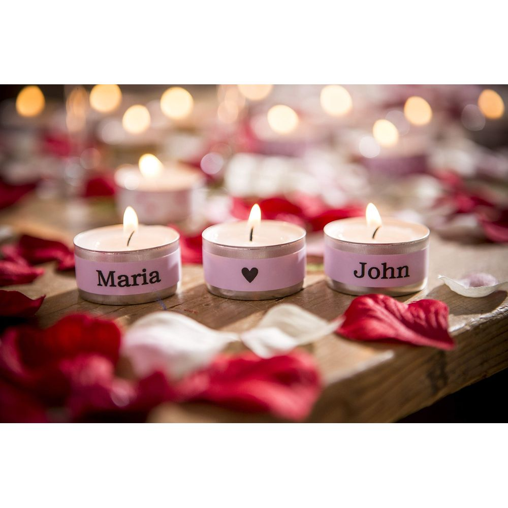 Drei Teelichter mit Namen 'Maria' und 'John', umgeben von Rosenblättern.