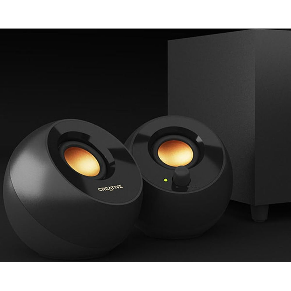 Dos altavoces negros y redondos con conos dorados junto a un subwoofer.
