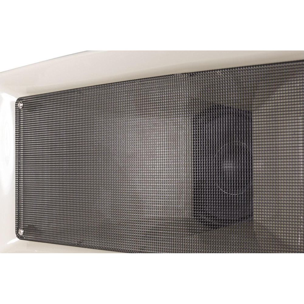 Una malla gris cubre la parte superior de un aparato blanco. Un altavoz negro es visible detrás.