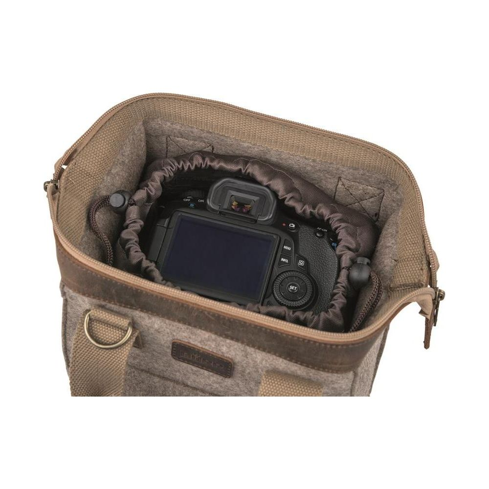 Una fotocamera DSLR nera riposa all'interno di una borsa in feltro marrone con accenti in pelle.