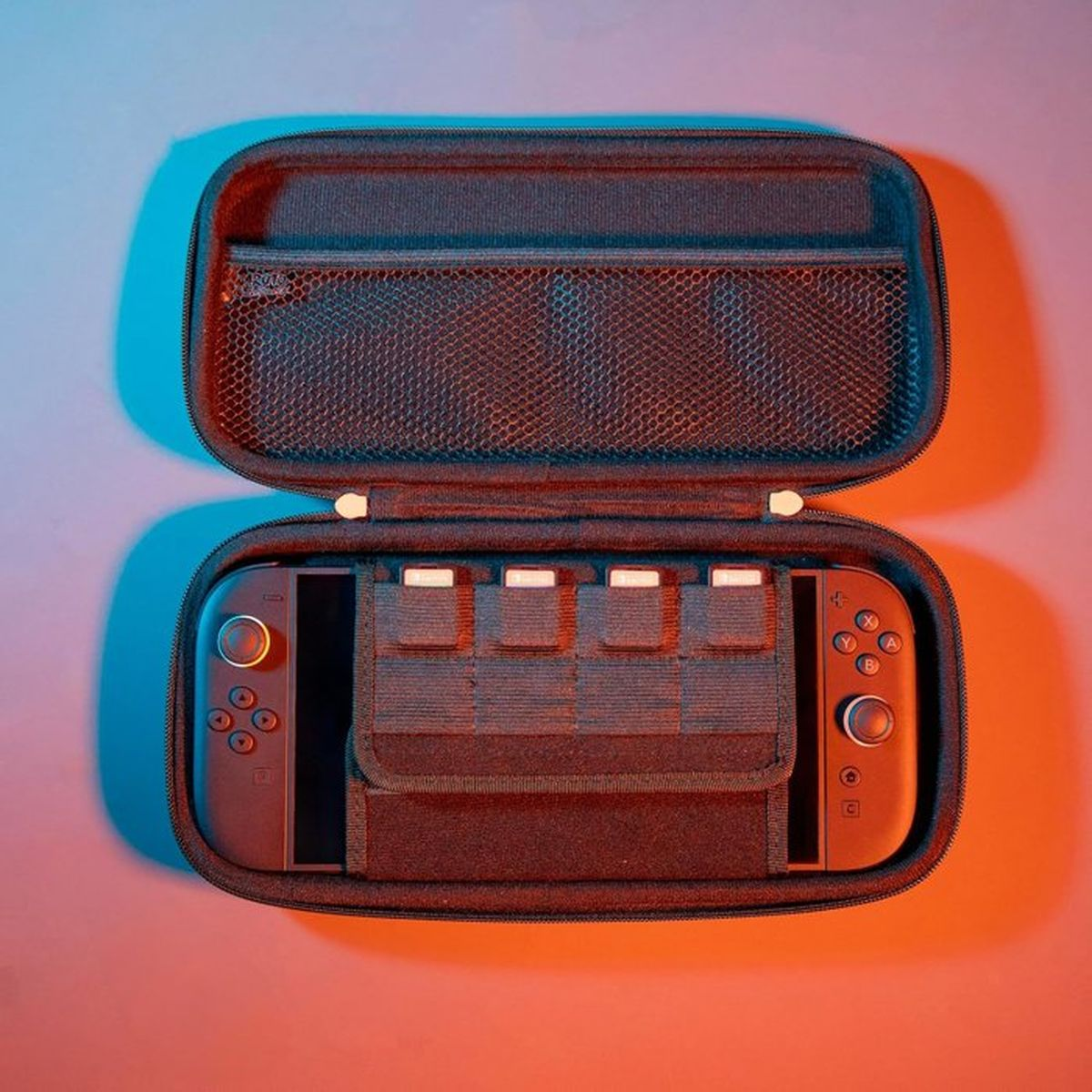 Ein schwarzer Reiseschutz für ein Handheld-Gerät, geöffnet mit dem Gerät und Speicherkartenhaltern im Inneren.