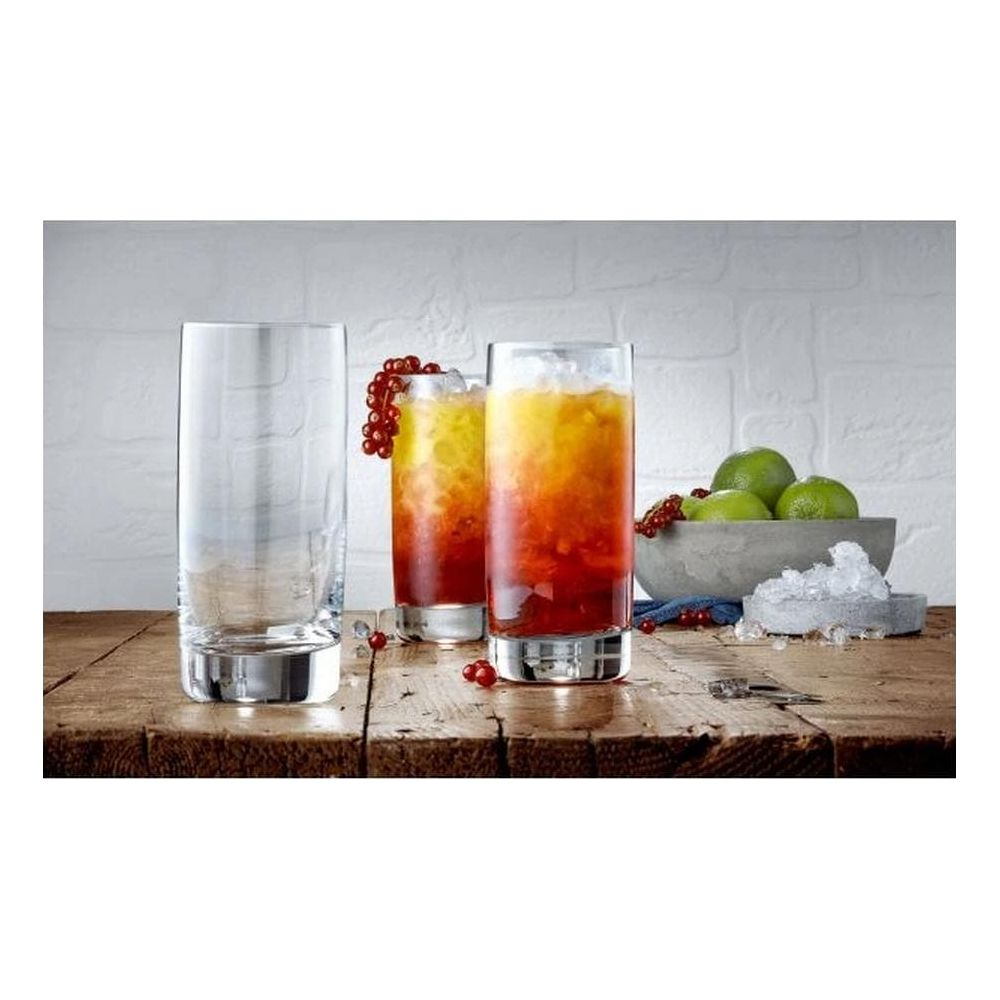 Ein leeres Glas und zwei bunte Cocktails stehen auf einem Holztisch.