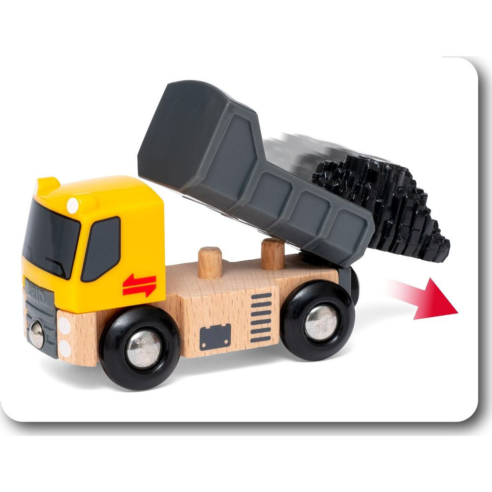 Un camion ribaltabile in legno giallo con cassone grigio che scarica carbone.