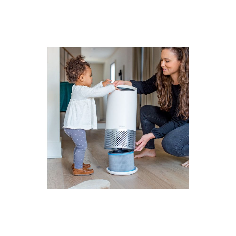 Kobieta i dziecko wymieniają filtr białej oczyszczarki powietrza.