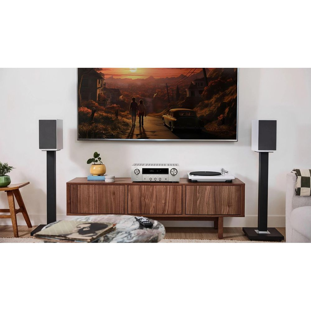 Soggiorno con TV, stereo, giradischi, altoparlanti e mobili.