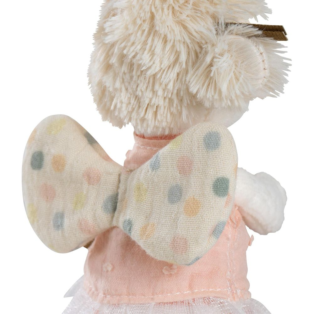 Une peluche vêtue d'une robe rose et d'ailes à pois.