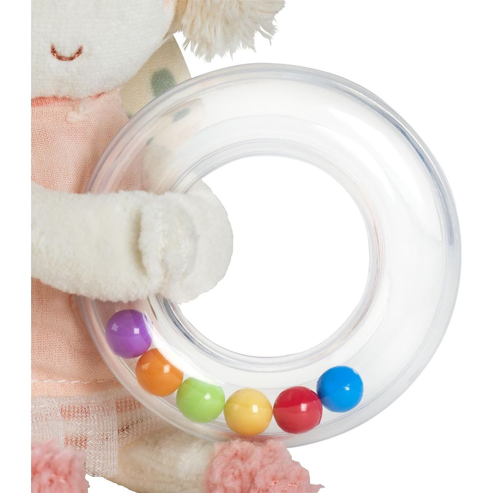 Un jouet en peluche tenant un hochet transparent avec des billes colorées.