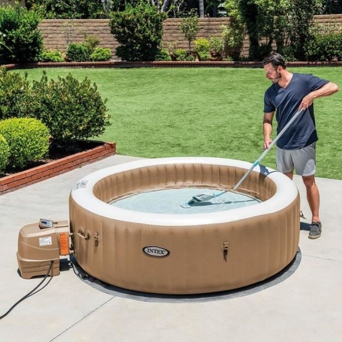 Mężczyzna czyści dmuchany jacuzzi w ogrodzie za pomocą siatki.