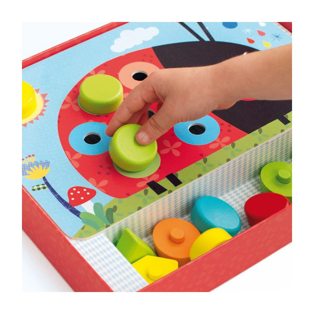 Un enfant place des pièces vertes dans un jeu sur le thème de la coccinelle.