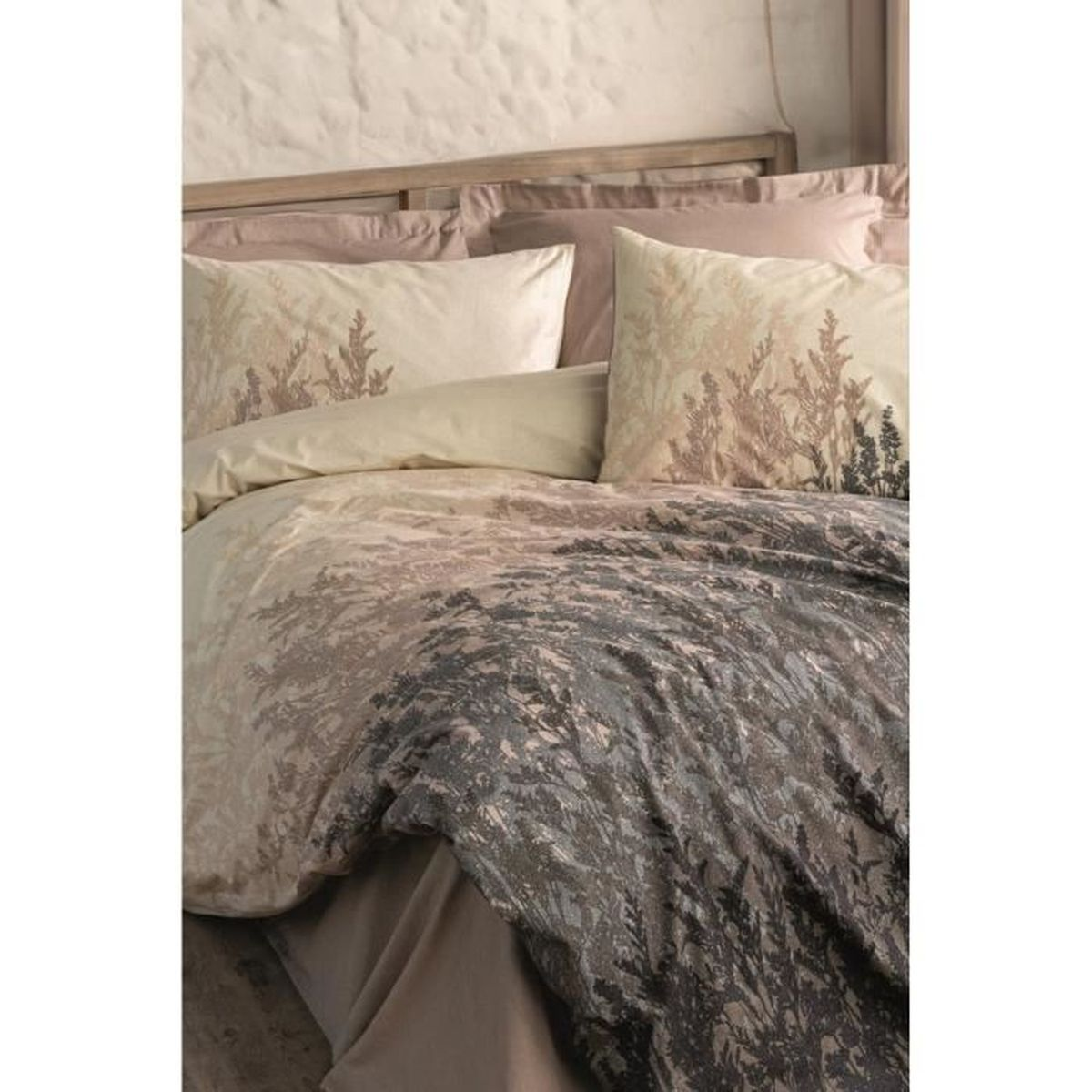 Bett mit Kissen und Decke, bedruckt mit einem Waldmotiv in Braun- und Grautönen.