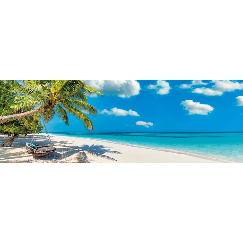 Una hamaca cuelga bajo una palmera en una playa de arena blanca con agua turquesa.