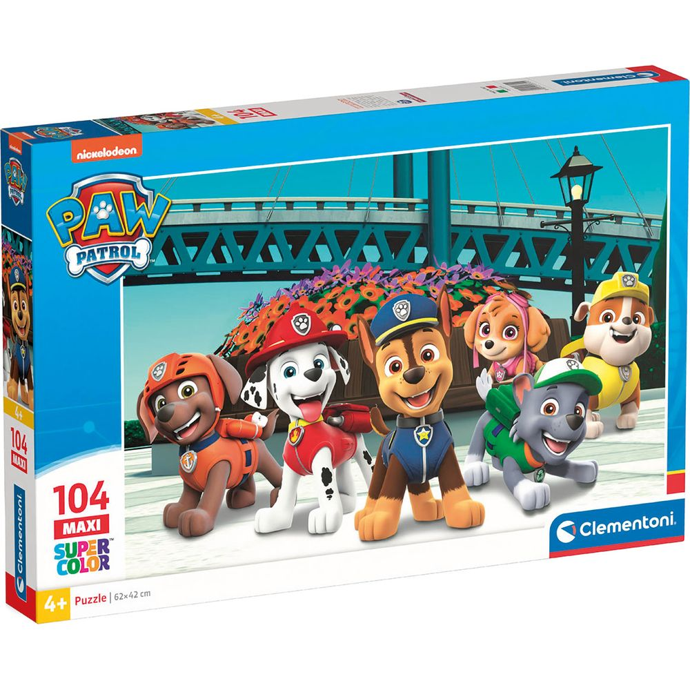 Pudełko z puzzlami Psiego Patrolu pokazujące sześć szczeniąt na rabatce przed mostem.