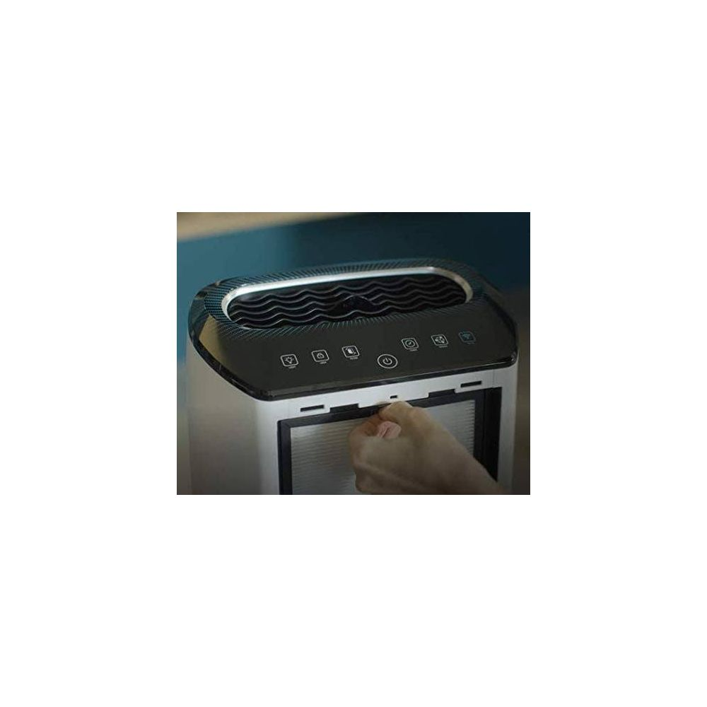 Una mano estrae un filtro da un purificatore d'aria bianco con pannello di controllo nero.