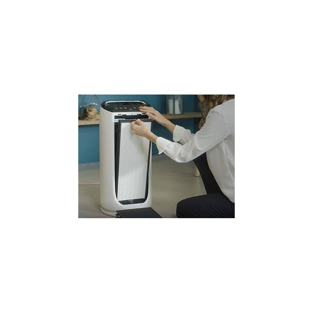Una donna sostituisce il filtro di un purificatore d'aria bianco.