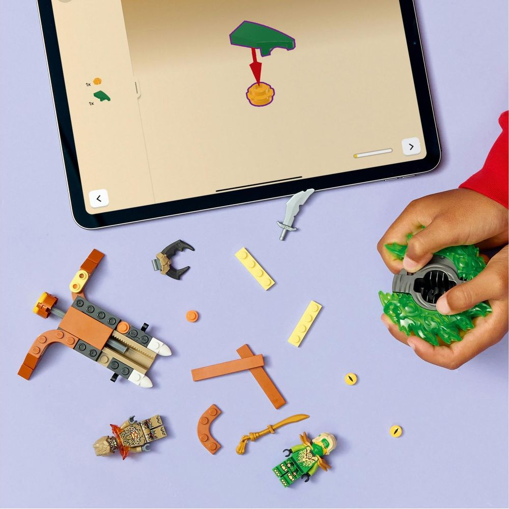 Bambino costruisce figura Lego con istruzioni su tablet, pezzi colorati.
