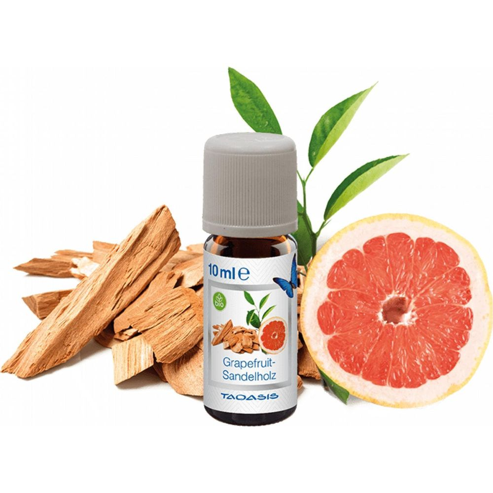 Ein Fläschchen Grapefruit-Sandelholz-Öl mit Grapefruit und Holzstücken.