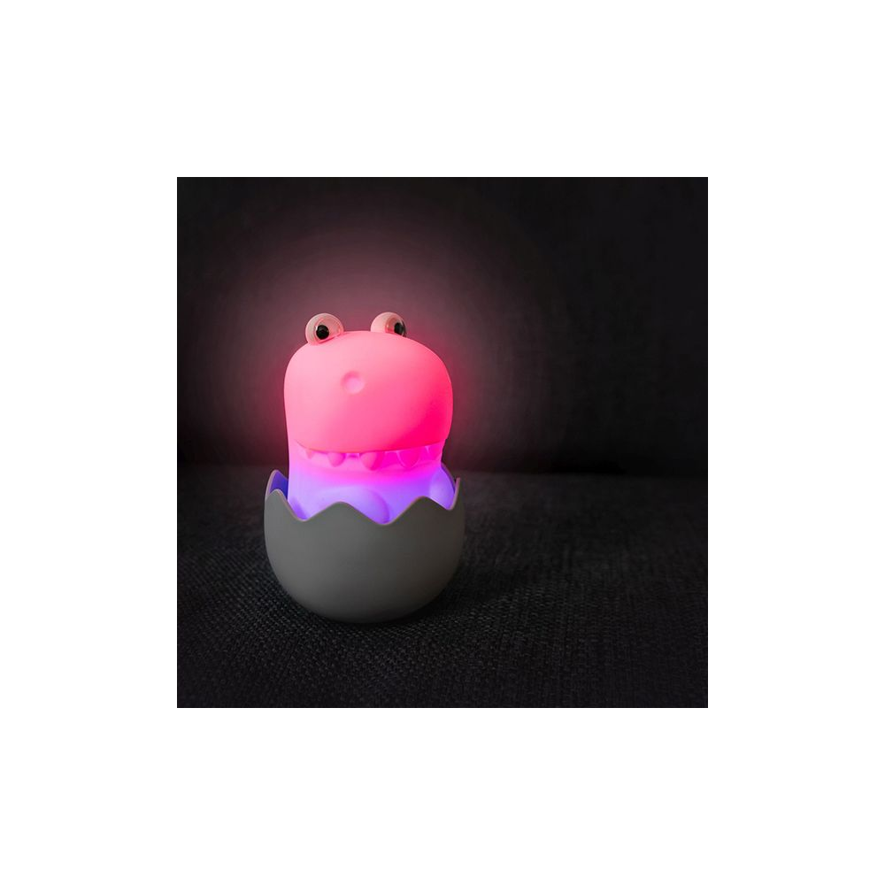 Ein pinker Dino-Nachtlicht in einem grauen Ei mit leuchtenden Augen.