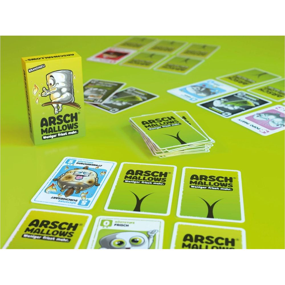 Jeu de cartes Arsch Mallows avec motifs de guimauve sur table verte.