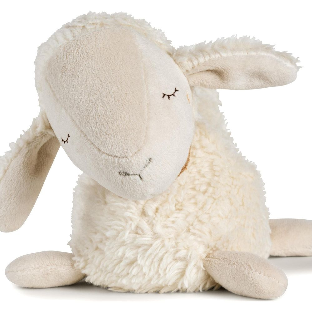 Un peluche di pecora morbido, color crema, seduto con gli occhi chiusi.
