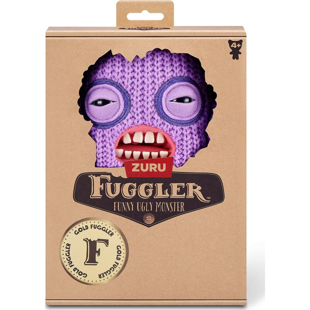 Un monstre tricoté violet avec de grands yeux et des dents, dans un emballage carton.