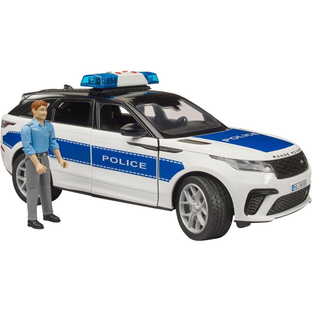 Ein Polizist steht neben einem weißen Polizeiauto mit blauen Streifen und Blaulicht.