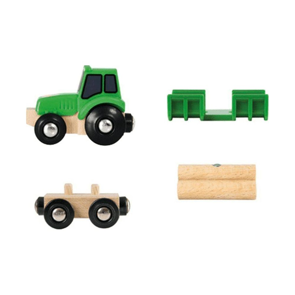 Ein grüner Holzspielzeugtraktor mit Anhänger und Holzstämmen.