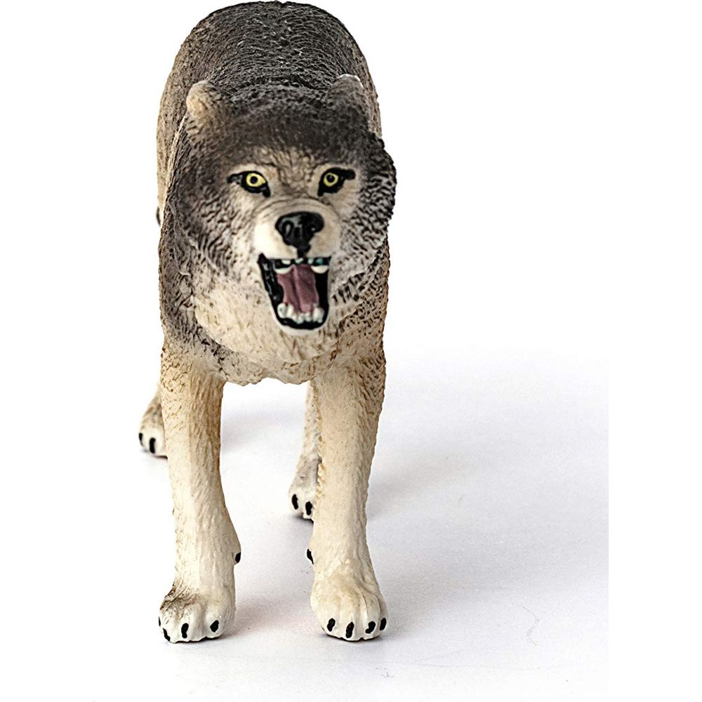 Zabawkowy wilk z otwartym pyskiem stoi na białym tle.