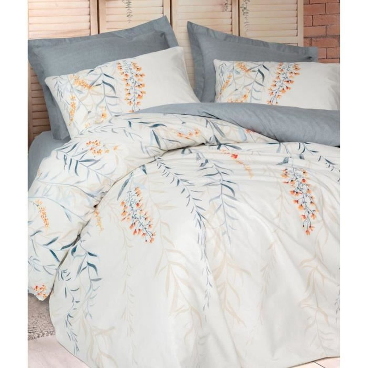 Ein Bett mit weißen Bettbezügen, verziert mit orange-blauen Blattmustern.