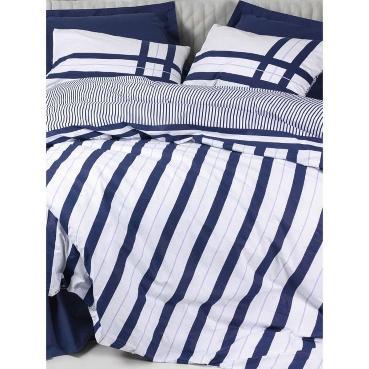 Bett mit blauen und weißen Streifen Bettwäsche und Kissen.